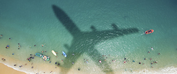 Airplane's shadow over a crowded beach