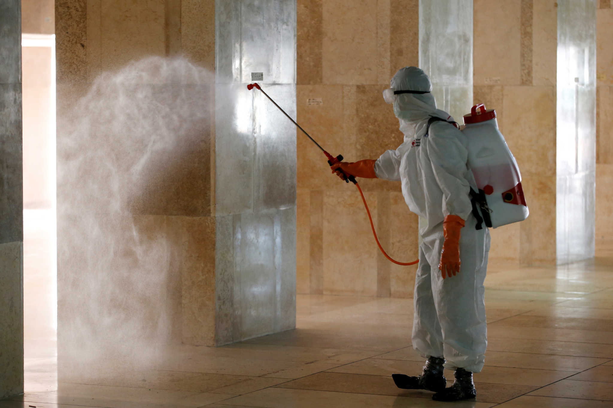 An Indonesian Red Cross personnel sprays disinfectant inside Istiqlal mosque, amid the coronavirus disease (COVID-19) in Jakarta, Indonesia, March 13, 2020. REUTERS/Willy Kurniawan